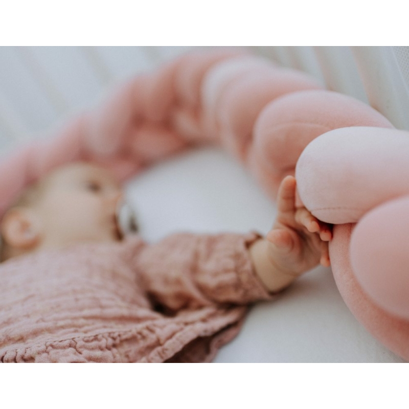 rózsaszín fonott rácsvédőt simogatja a kisbaba